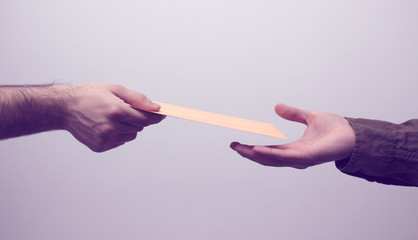 Two men hands receiveng and giving mail in envelope on the white background. Mailtime concept....