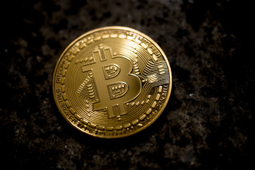 Golden bitcoin on dark grunge background, close up