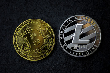 Golden Bitcoin and Silver Litecoin on dark blue grunge background, close up