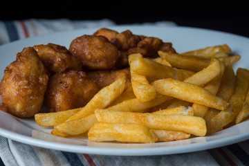 Chicken pieces and french fries on a plate