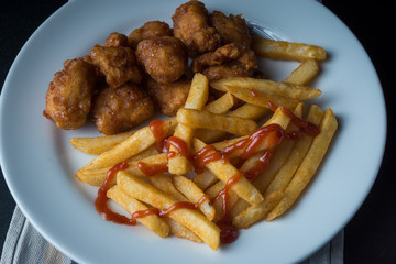Plate of french fries and chicken