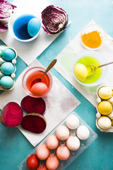Dyeing eggs for Easter holidays, coloring with different red  color and tonality using food colorant over a gray concrete background