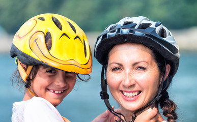 Happy mother and daughter with bike helmet
