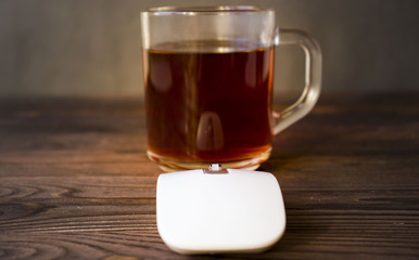 Cup of tea and a white mouse on a wooden table