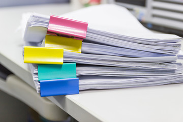 Stack of papers documents in archives files with paper clips on desk at offices, business concept.