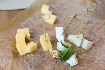 .Appetizer from cubes of various cheese, mint and walnut on parchment