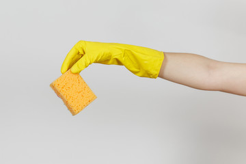 Close up of female hand in yellow gloves horizontal holds yellow-orange sponge for cleaning and...