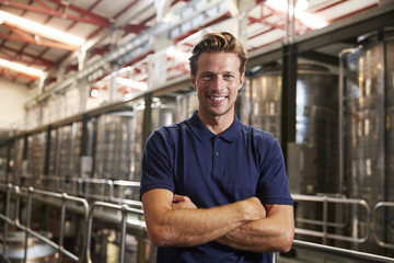 Portrait of a young white man working at a wine factory