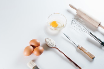 Ingredients for bakery, flour, eggs, yolk, spoon, mixer, rolling pit.