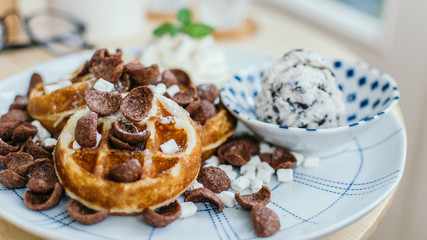 Cocoa crunch waffle with ice cream in cafe.