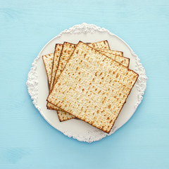 passover background with matzoh over light blue wooden background.