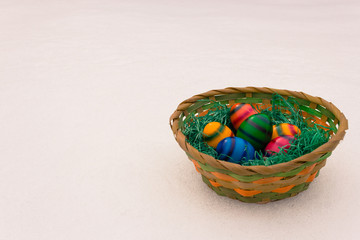 colored easter egss in a basket with green grass in it