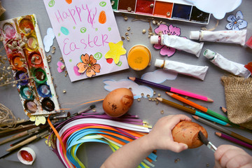 A child paints Easter eggs. Easter composition