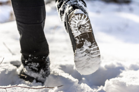 Person hiking with boots in snow, shoe sole