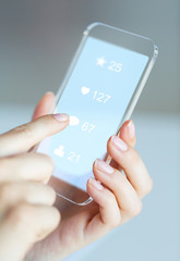 hands with social media icons on smartphone