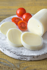 Sliced Formaggio with cherry tomatoes on the wooden board