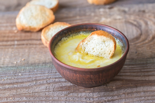 Bowl of cheese dip with toasts