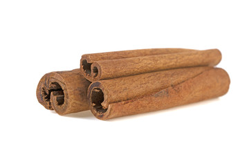 three cinnamon sticks on white background