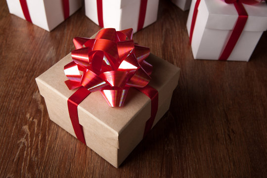 One festive gift box with a red bow against a background of white boxes