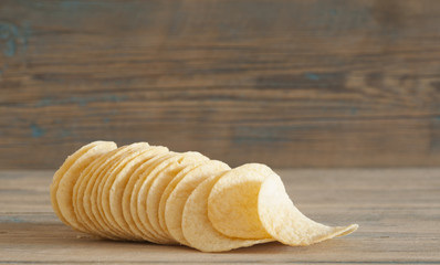Golden natural potato chips on an old wooden table