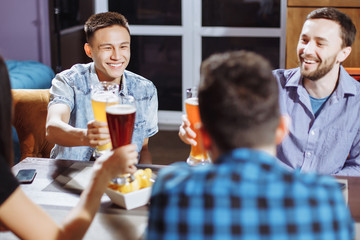 People, men, leisure, friendship and celebration concept - happy male friends talking and drinking beer at bar or pub.