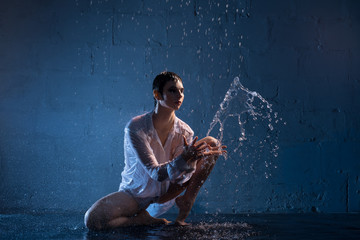 Woman in wet white shirt playing with water