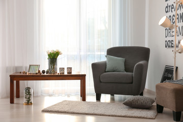 Elegant living room interior with comfortable armchair and table