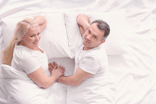 Senior couple in bed together, top view