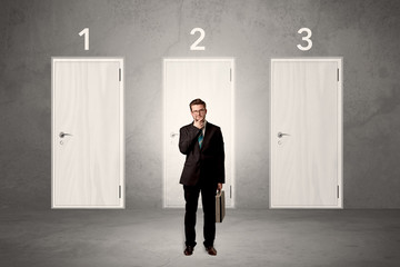 Fototapeta premium Businessman thinking in front of three doors