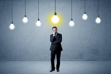 Obraz premium Businessman standing uninspired with bulbs above