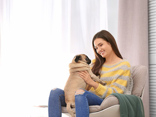 Woman with cute dog at home. Friendship between pet and owner