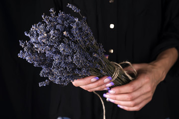 Female florist tying up fresh bouquet with lavender