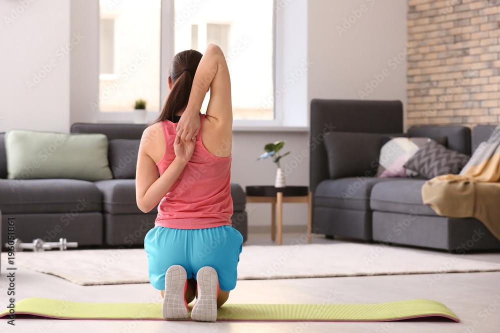 Canvas Prints Young sporty woman stretching at home