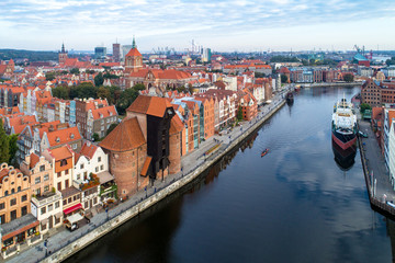 Gdansk old city in Poland with the oldest medieval port crane (Zuraw) in Europe,  St John church, Motlawa River, old granaries, ships and boat. Aerial view in early morning.   © nahlik