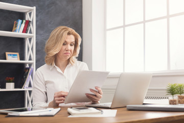 Businesswoman reading document at office desktop