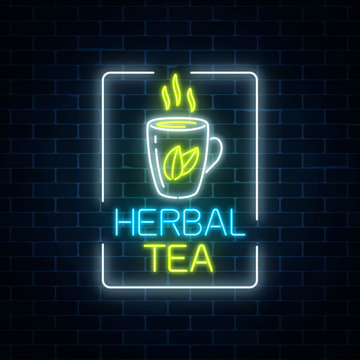 Glowing neon cup of herbal tea sign in rectangle frame on dark brick wall background. Healthy lifestyle concept.