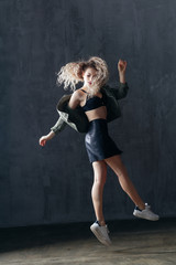 Young beautiful female dancer is posing in the studio