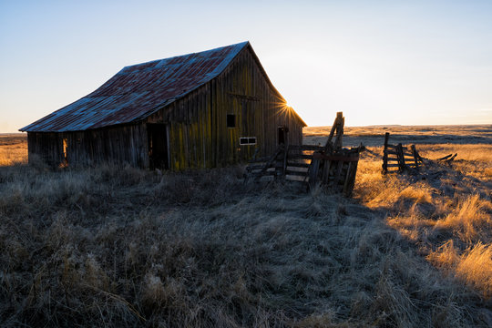 The sun sets on an old barn