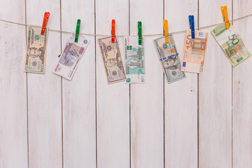 money from different countries attached to the rope clothespins.