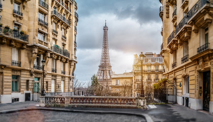 The eiffel tower in Paris from a tiny street - obrazy, fototapety, plakaty