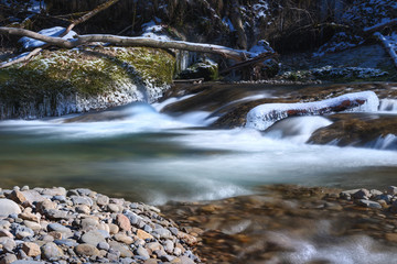 Fototapeta premium hanging icicles on rocks at the mountain lake