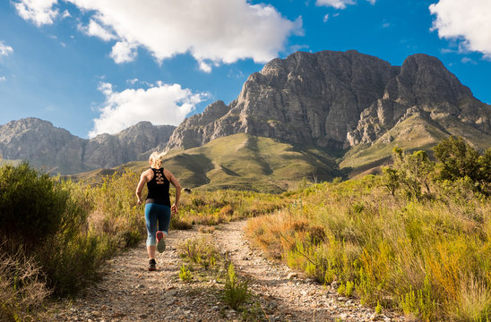 female trail runner in the mountains with beautiful light