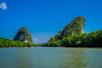 Fototapeta na wymiar Beautiful outdoor view of huge mountains in the horizont, viewed from the river during a gorgeopus blue asky in Krabi Province, South of Thailand
