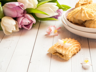 Biscuits and tulips on a wooden table