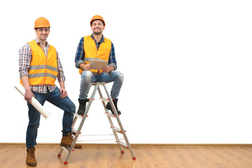 The two engineers near the ladder on the white wall background
