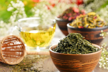 Composition with cup of tea and bowls of tea leaves