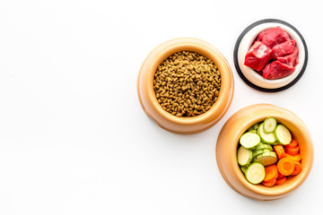Ingredients for dry pet food. Meat and vegetables zucchini and carrot on white backgroud top view copy space