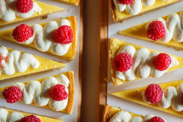 product photography of lemon cheesecake with raspberries on white background, zig zag pattern of...