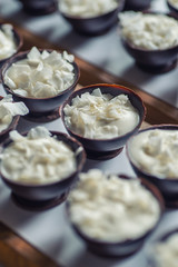 chocolate sweet dessert filling with coconut cream and coconut petals on top, product photography fot patisserie