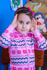 cute girl on the background of her toys smiling